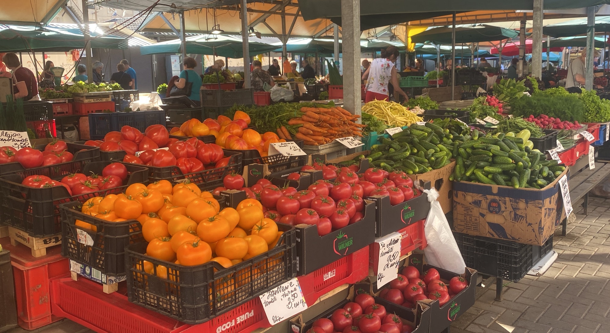 Market stall of tomatoes, carrots and cucumbers